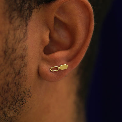 Close up view of a model's ear wearing a 14k gold Tanlah Earring horizontally