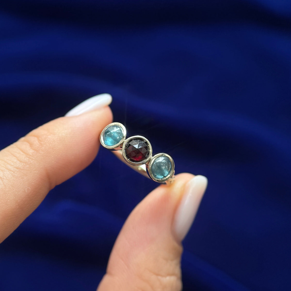 top view of 14k Yellow Gold Bezel-set 5mm Rose-cut Garnet with 2pc 5mm Teal Cabochon Diamonds on a 2.5mm Mix Mirror Band Custom Ring, Size 6