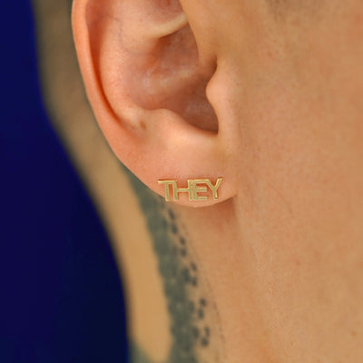 Close up view of a model's ear wearing a 14k gold They Earring