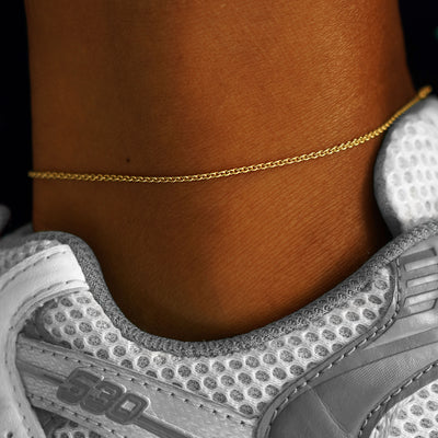 A model's ankle wearing a yellow gold Thick Cable Anklet