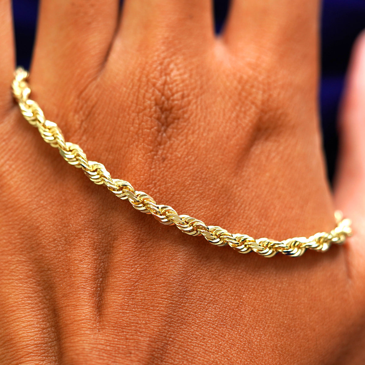 A solid gold Thick Rope Chain resting on the back of a model's hand