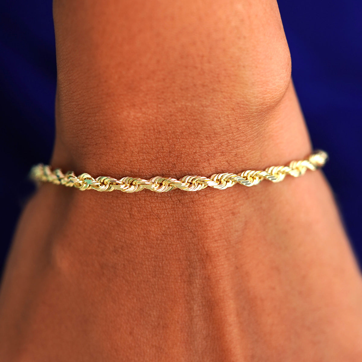 Close up view of a model's wrist wearing a yellow gold Thick Rope Chain Bracelet