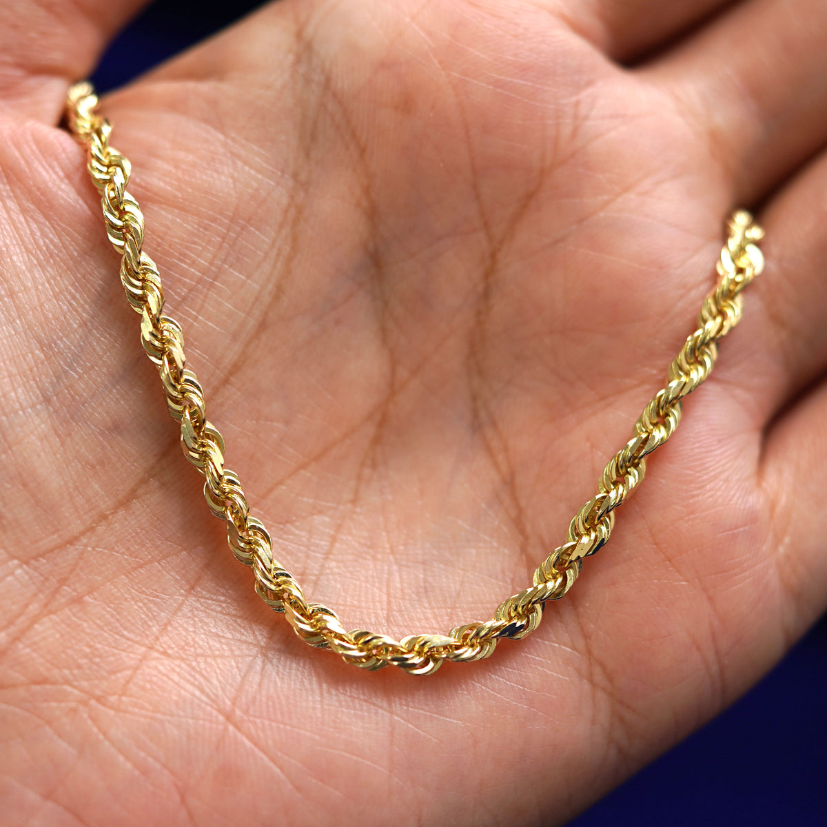A yellow gold Thick Rope Chain draped on a model's palm