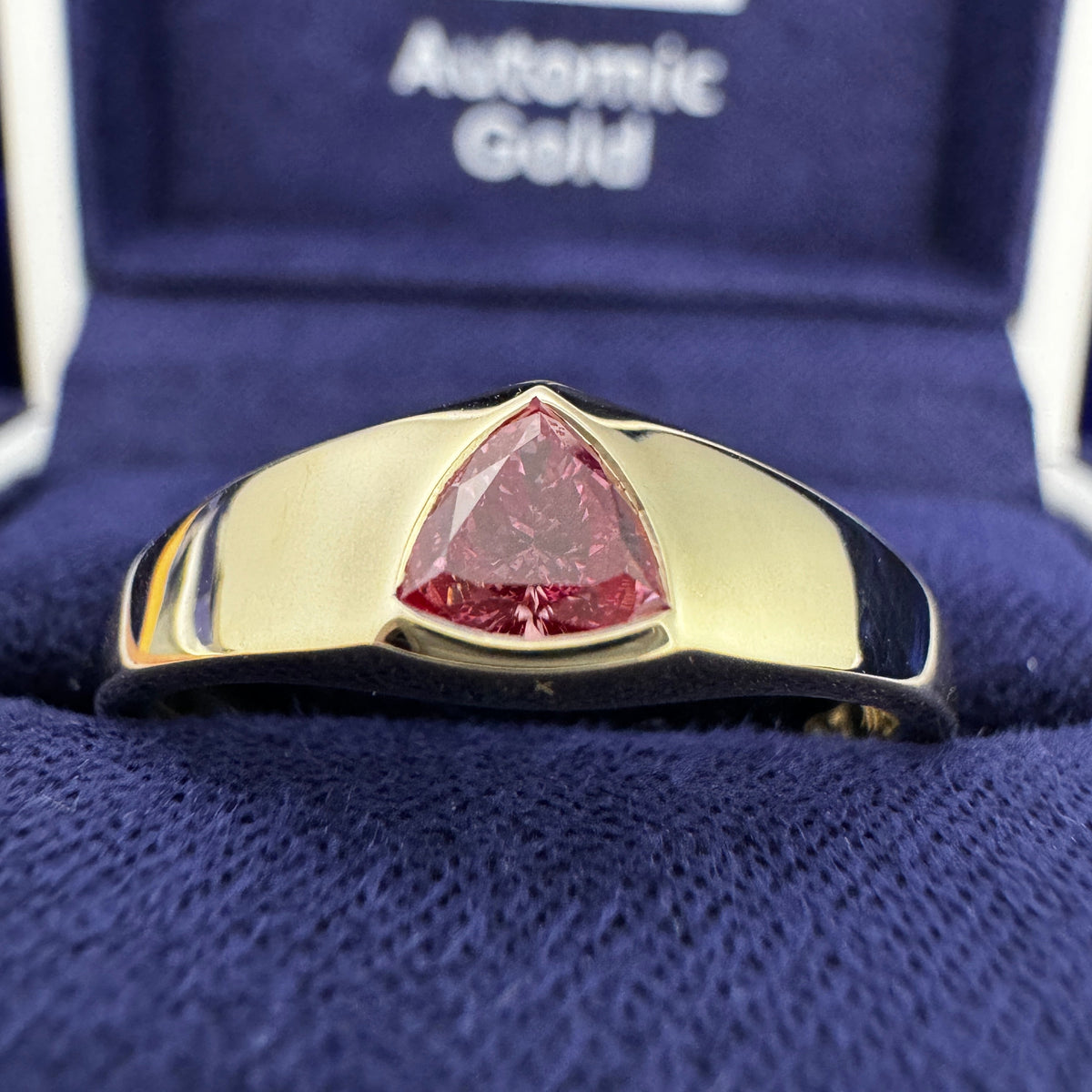 14k Yellow Gold Bezel-set 5mm Trillion Pink Lab Diamond on Tapered Band Custom Ring in a blue ring box