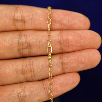 An Automic Gold AU lobster claw clasp on a 14 karat gold Veren Anklet