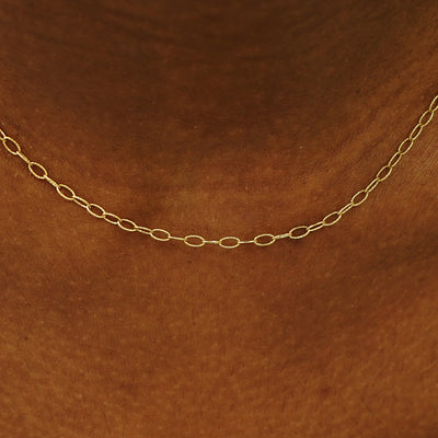 Close up view of a model's neck wearing a solid yellow gold Veren Chain