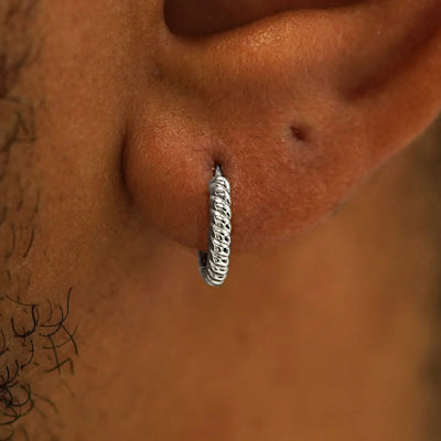 A model's ear wearing a 14k white gold Small Rope Huggie Hoop Earring