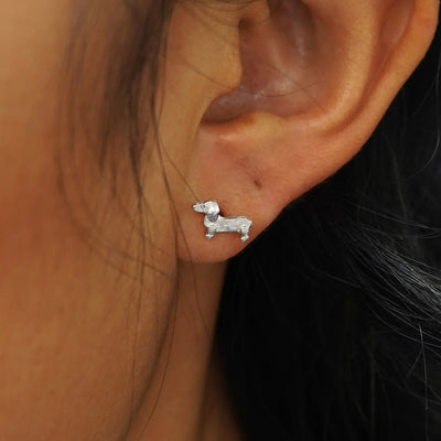 Close up view of a model's ear with a white gold Dog Earring.
