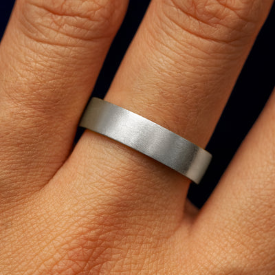 Close up view of a model's fingers wearing a 14k white gold Industrial Matte Band