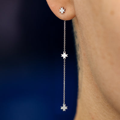 Close up view of a model wearing a 14k white gold 8 pointed star extender with an 8 pointed star stud earring