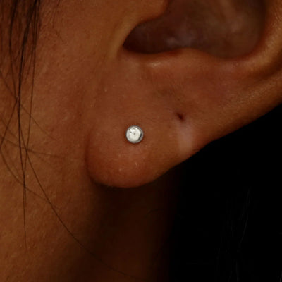 A model's ear wearing a solid white gold Small Ball Earring