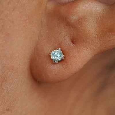 Close up view of a model's ear wearing a 14k white gold Aquamarine Earring