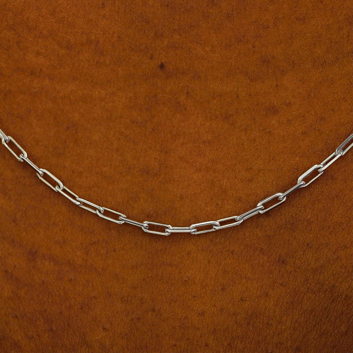 Close up view of a model in a white shirt wearing a white yellow gold Butch Chain