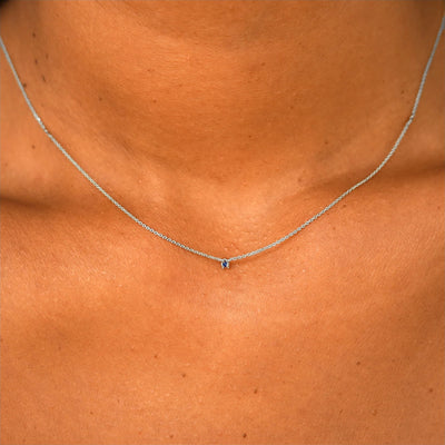 Close up view of a model's neck wearing a solid 14k white gold Gemstone Cable Necklace in sapphire