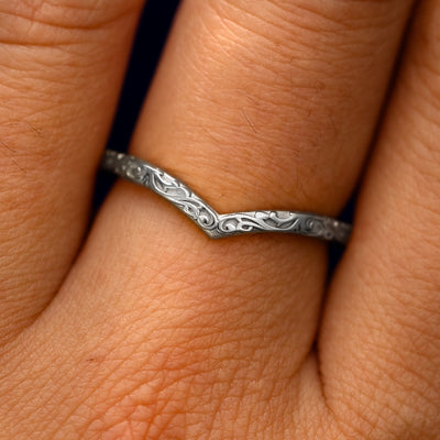 Close up view of a model's fingers wearing a 14k white gold Chevron Filigree Band
