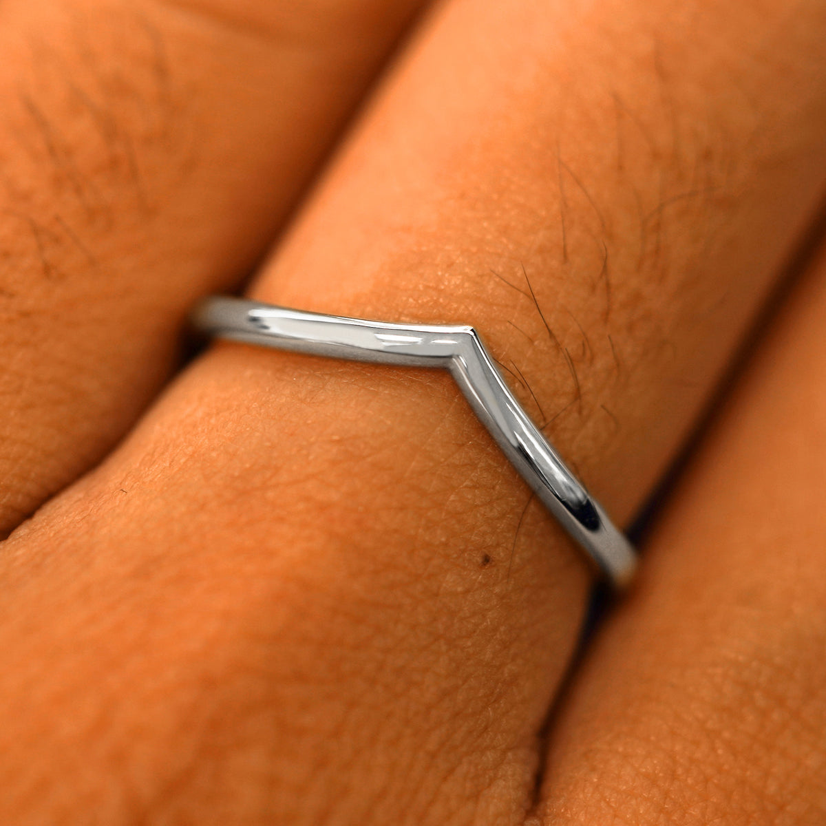 Close up view of a model's fingers wearing a 14k white gold Chevron Band