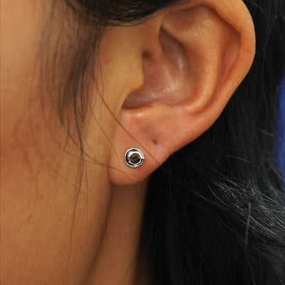 Close up view of a model's ear wearing a white gold Coffee Cup Earring