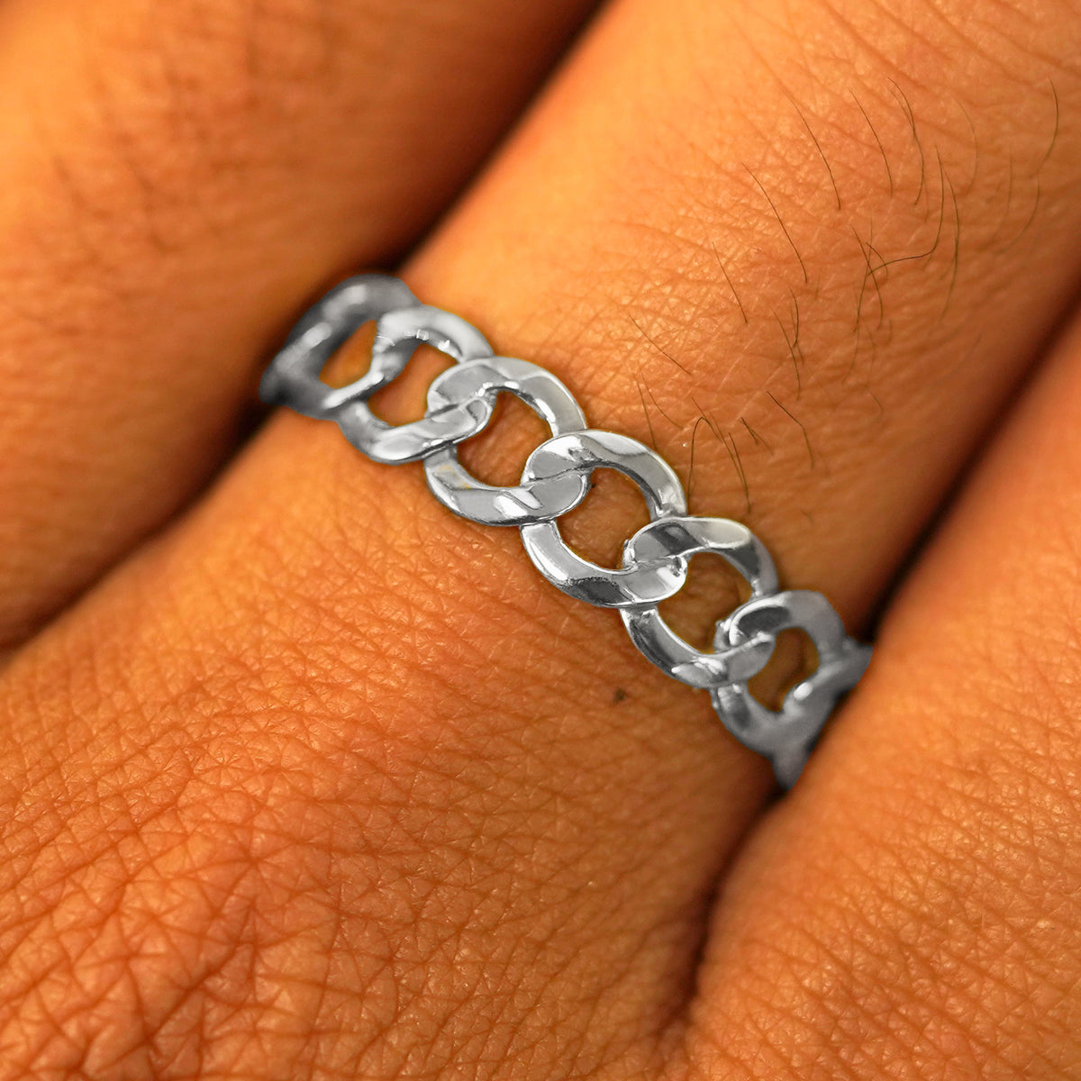 Close up view of a model's hand wearing a solid white gold Curb Ring