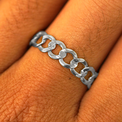 Close up view of a model's hand wearing a solid white gold Curb Ring