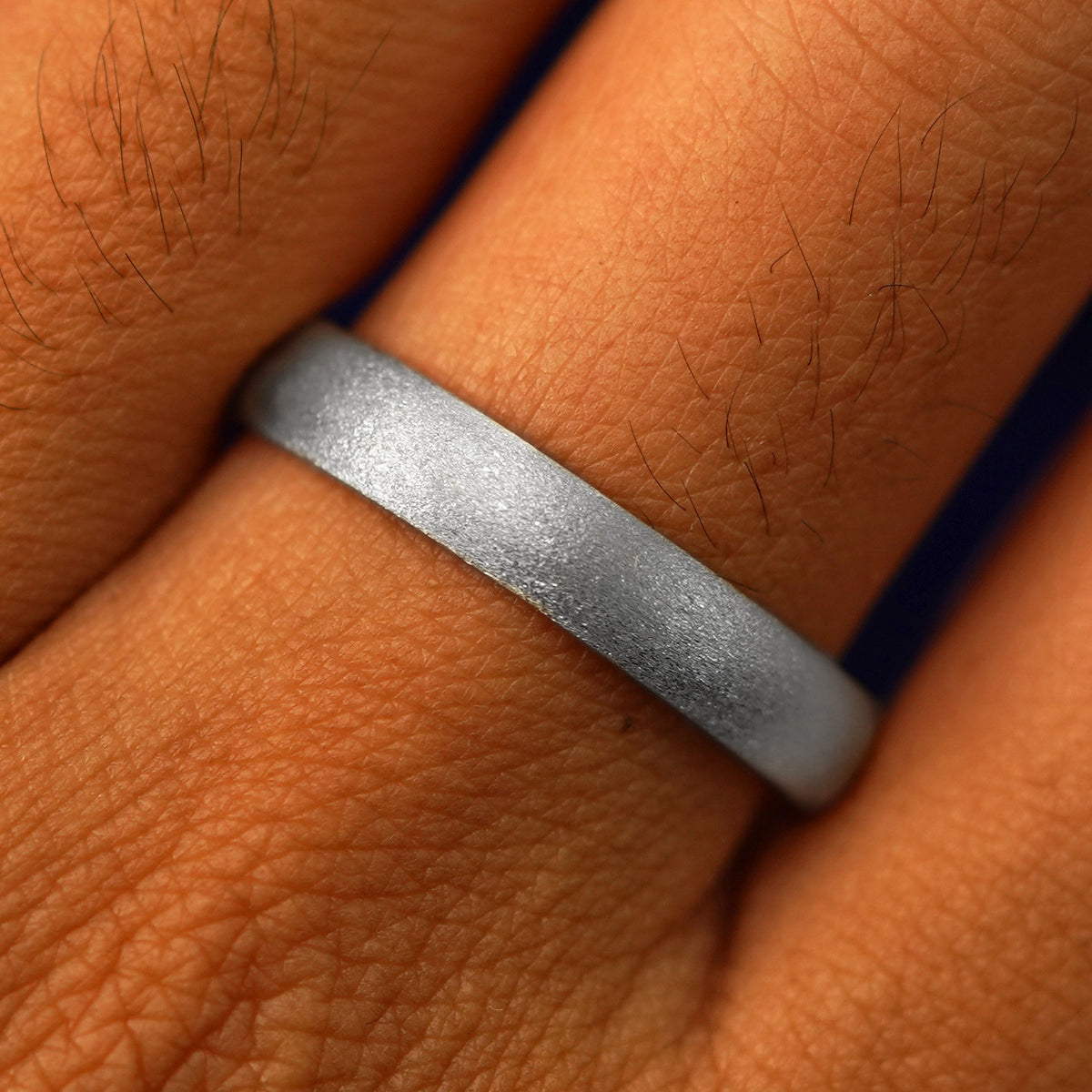 Close up view of a model's fingers wearing a 14k white gold Curvy Stardust Band