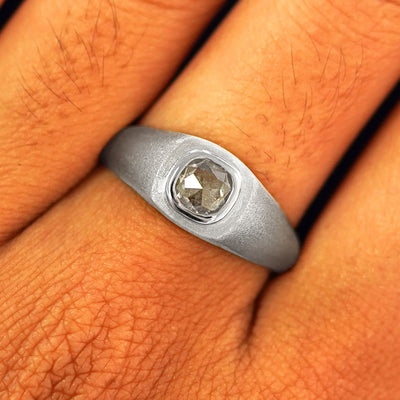 Close up view of a model's fingers wearing a 14k white gold Cushion Salt and Pepper Diamond Signet Ring