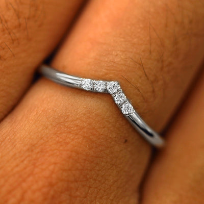 Close up view of a model's fingers wearing a 14k white gold Diamond Chevron Band