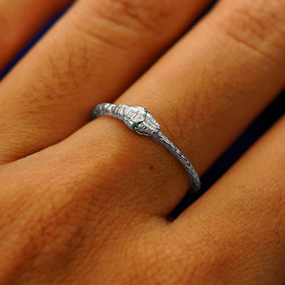 Close up view of a model's hand wearing a white gold emerald Gemstone Ouroboros Snake Ring