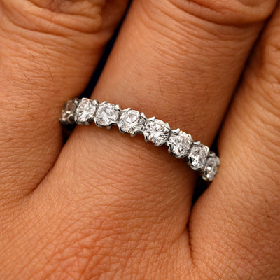 Close up view of a model's fingers wearing a 14k white gold Petal Set Diamond Eternity Band