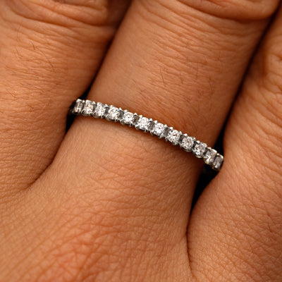 Close up view of a model's fingers wearing a 14k white gold Mini Petal Set Diamond Eternity Band