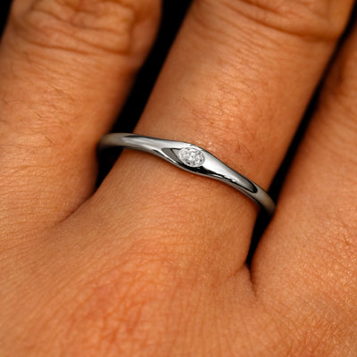 A 14k white gold Flush Set Oval Diamond Ring on a model's finger