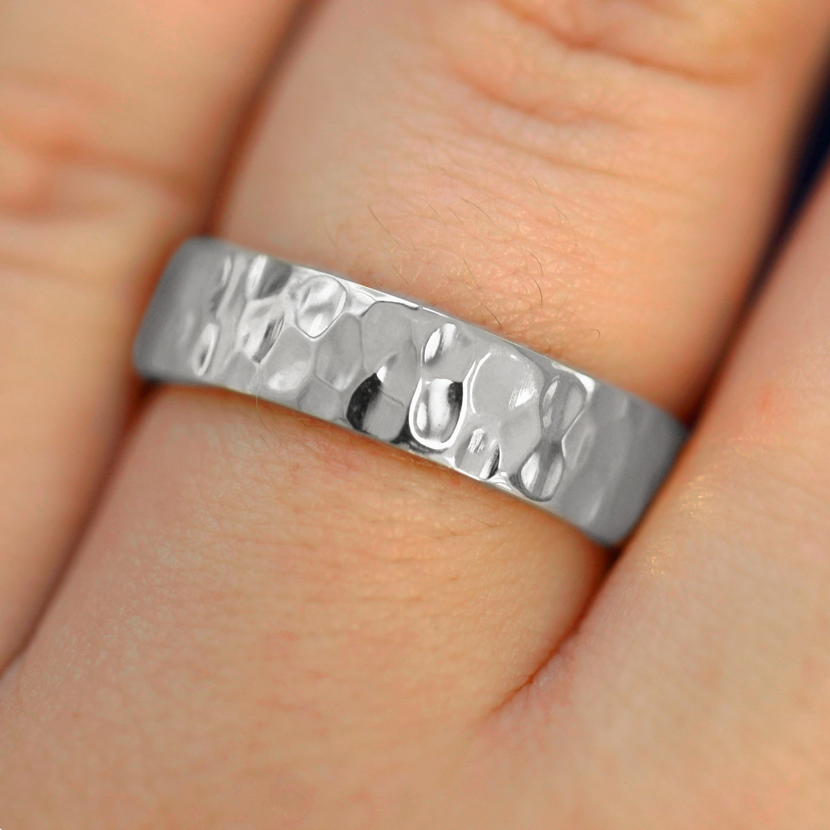 Close up view of a model's fingers wearing a 14k white gold Industrial Hammered Band
