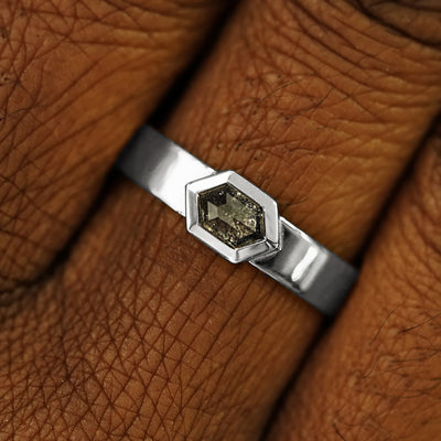 Close up view of a model's hand wearing a solid white gold Hexagon Diamond Band