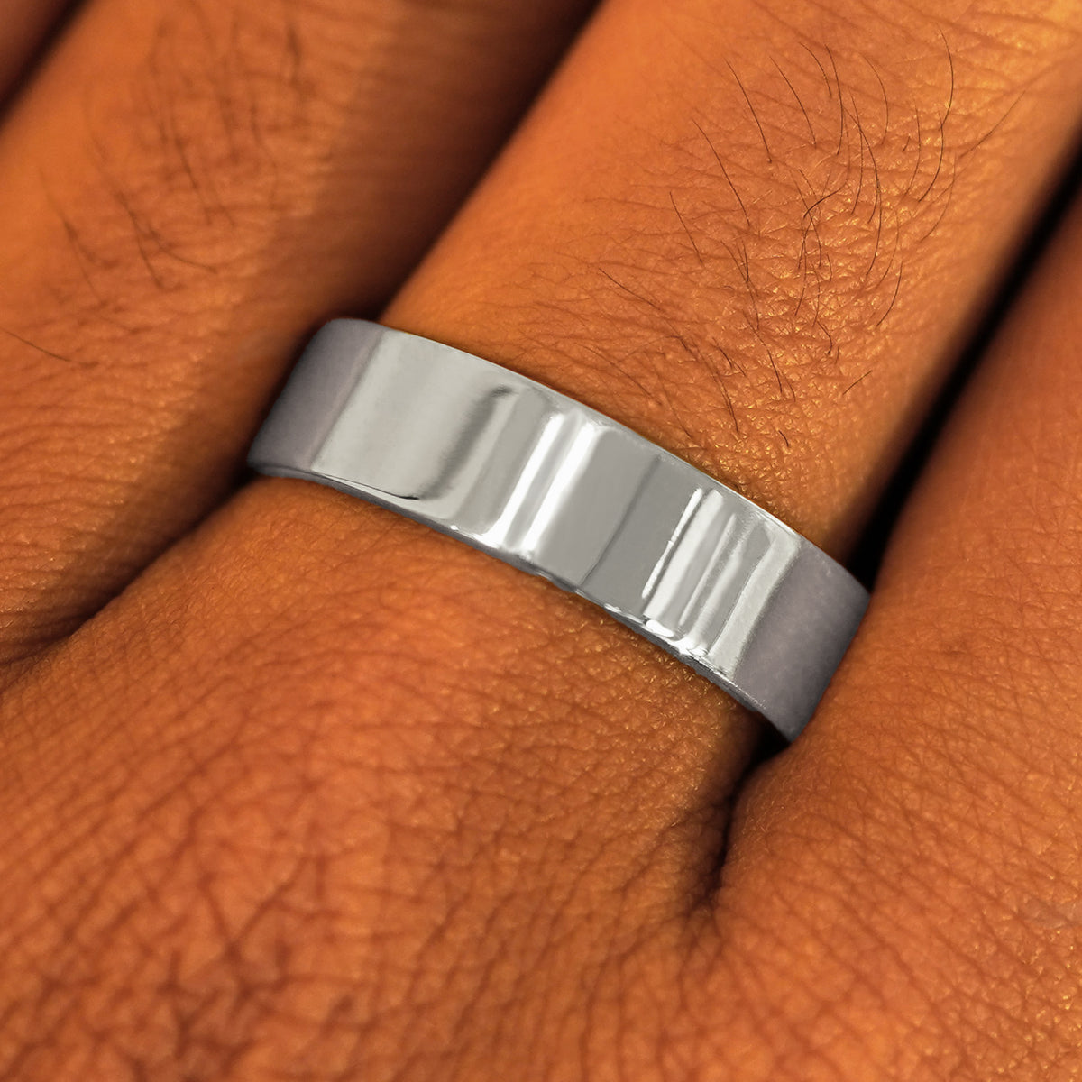 Close up view of a model's fingers wearing a 14k white gold Industrial Mirror Band