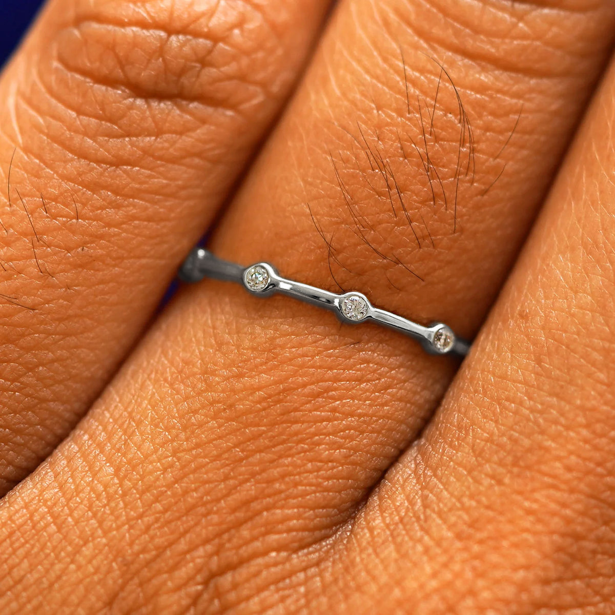 Close up view of a model's fingers wearing a 14k white gold Spaced Infinity Ring