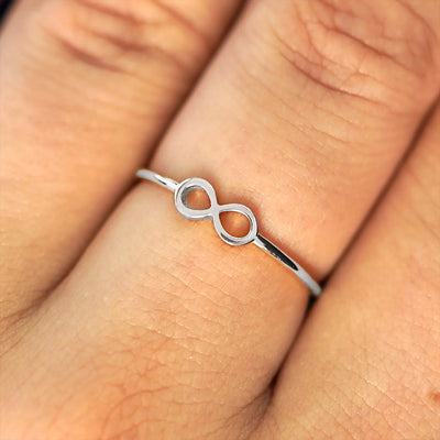 Close up view of a model's fingers wearing a 14k white gold Infinity Ring