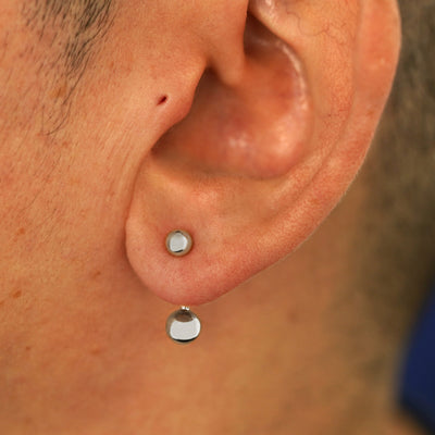 Close up view of a model's ear wearing a 14k white gold Large Curved Barbell through a lobe piercing