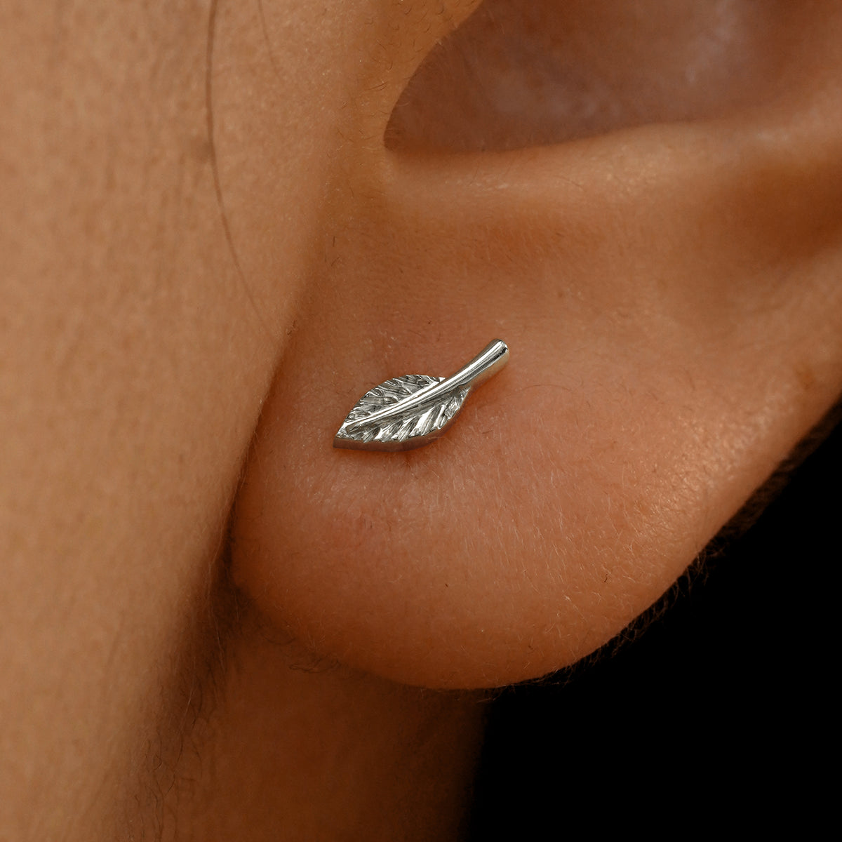 Close up view of a model's ear wearing a 14k white gold Leaf Earring