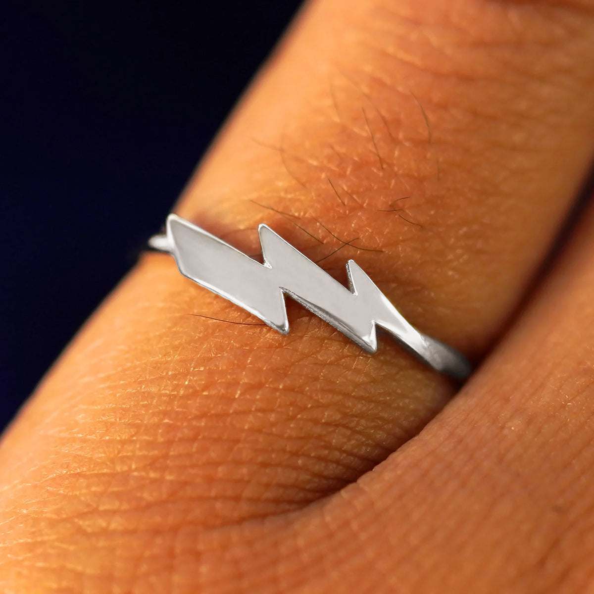 Close up view of a model's hand wearing a white gold Lightning Bolt Ring