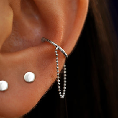 Close up view of a model's ear wearing a 14k white gold line cuff Earring