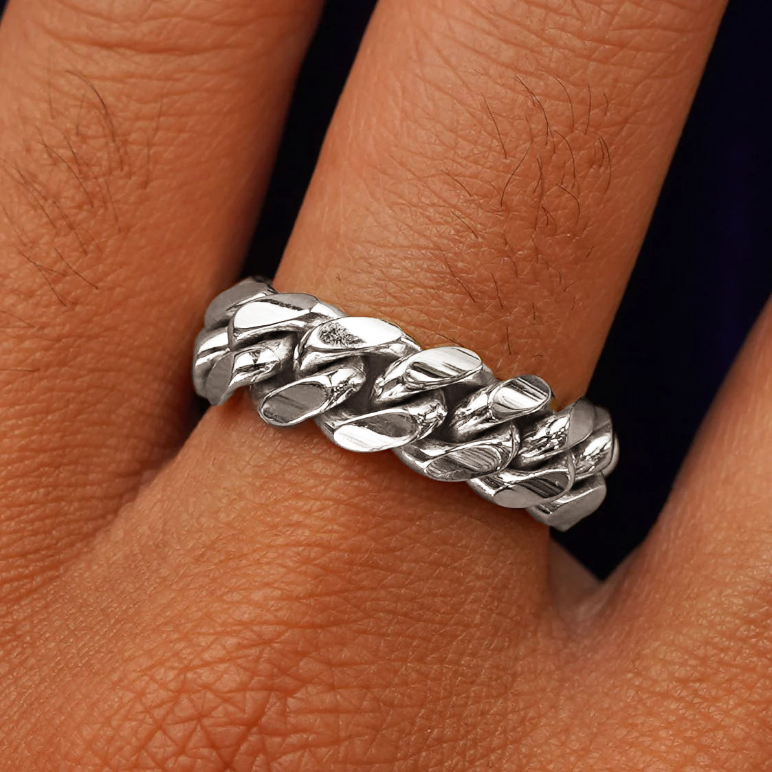 Close up view of a model's hand wearing a white gold Miami Cuban Ring