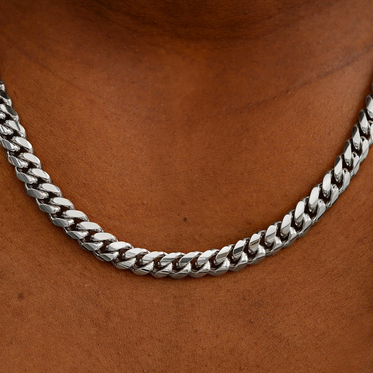 Close up view of a model's neck wearing a white gold Miami Cuban Chain