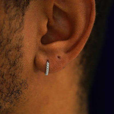 A model's ear wearing a 14k white gold Mini Rope Huggie Hoop Earring