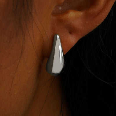 Close up view of a model's ear wearing a white gold black 5mm Moissanite Earring