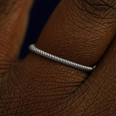Close up view of a model's fingers wearing a 14k white gold Rope Ring