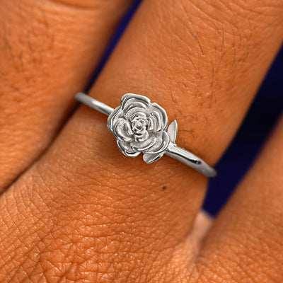 Close up view of a model's fingers wearing a 14k white gold Rose Ring
