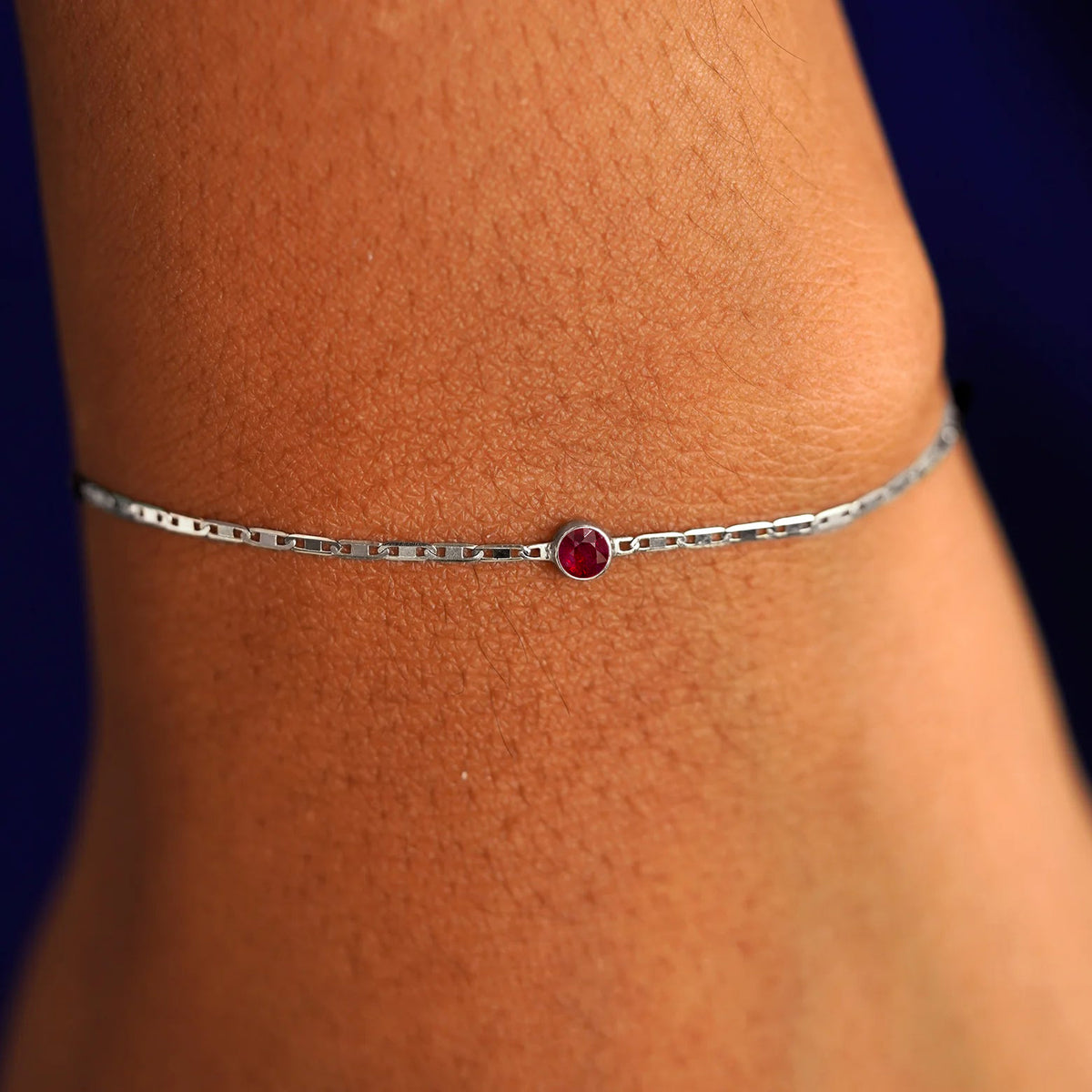 A model's wrist wearing a 14 karat white gold Ruby Bracelet