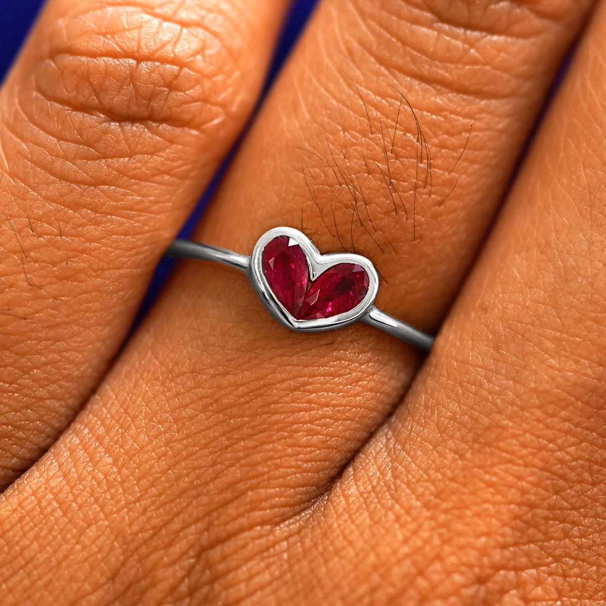 Close up view of a model's fingers wearing a 14k white gold Ruby Heart Ring