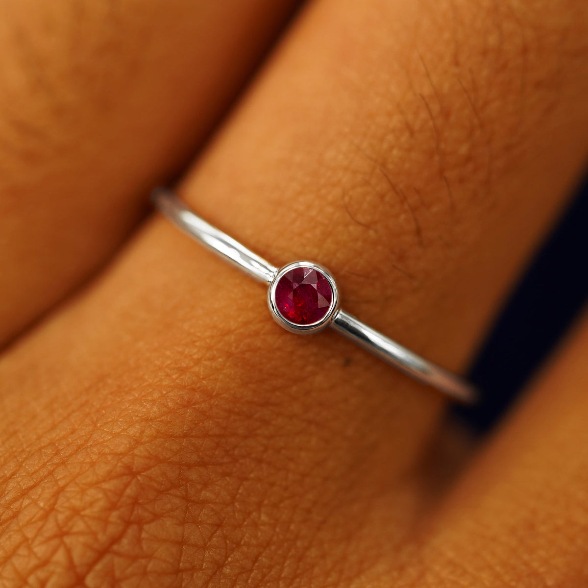 Close up view of a model's hand wearing a white gold Ruby Ring