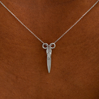Close up view of a model's neck wearing a solid 14k white gold Scissors Necklace
