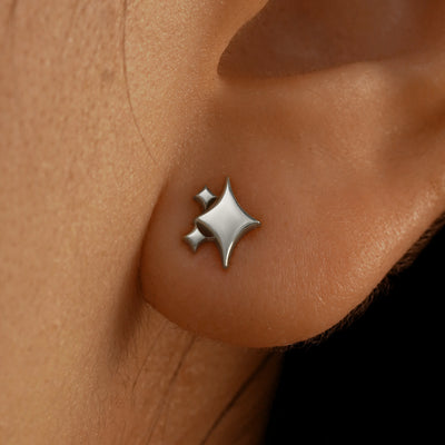 Close up view of a model's ear wearing a 14k white gold Sparkly Emoji Earring